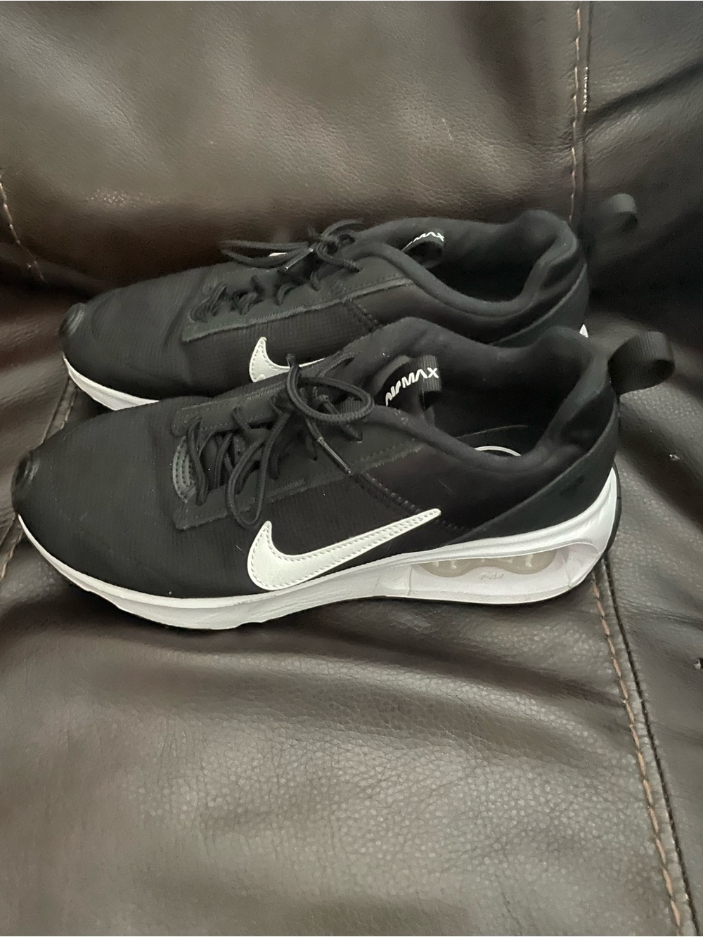 Nike Air Max INTRLK Lite shoes in black with a white swoosh.